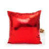 A square red pillow covered in metallic shine fabric.