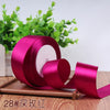 Roll of vibrant magenta satin ribbon for gift wrapping and DIY crafts