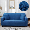 A deep blue stretch floral elastic sofa cover on a sofa, with a circular blue fabric accent.