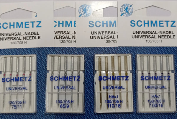 A collection of SCHMETZ universal sewing machine needles packaged in plastic trays.