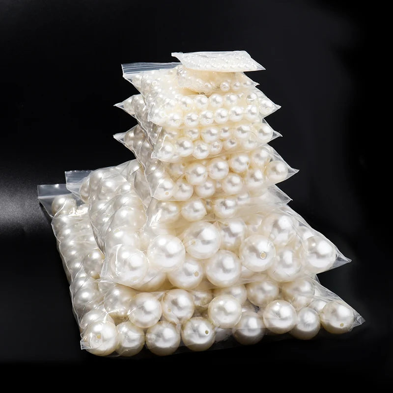 A pile of white imitation pearl beads packaged in clear plastic.