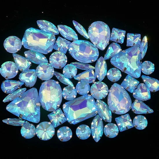 A collection of sparkling blue and white silver claw rhinestones arranged in a circular pattern.