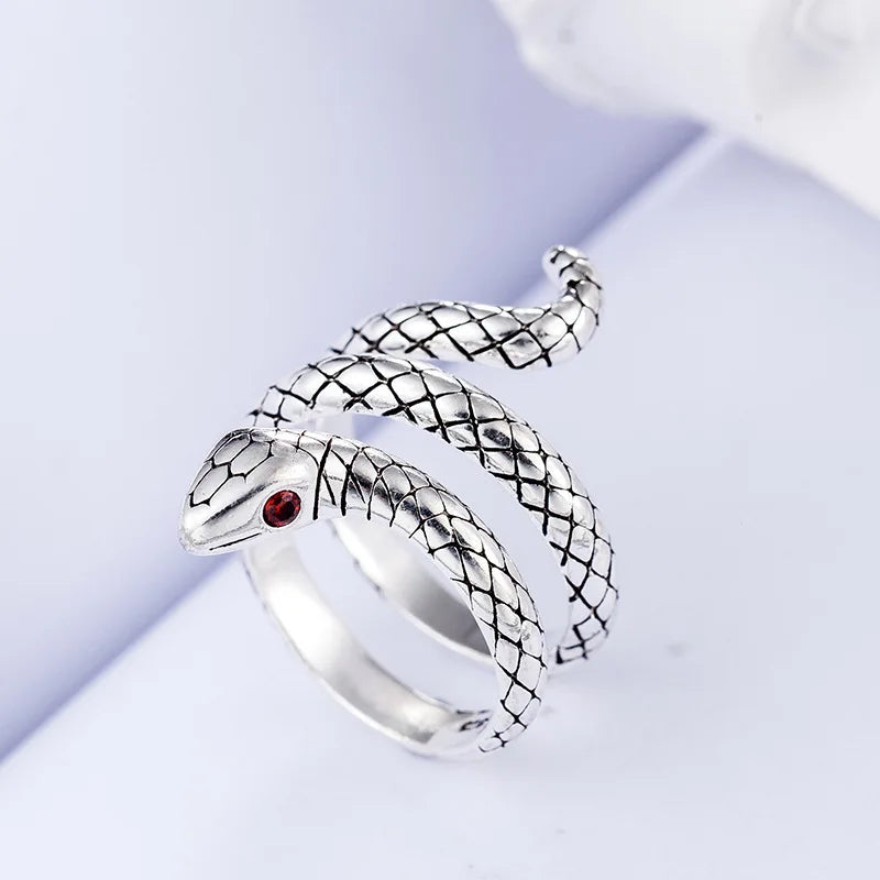 Silver animal finger rings featuring a textured snake design and a red gemstone.