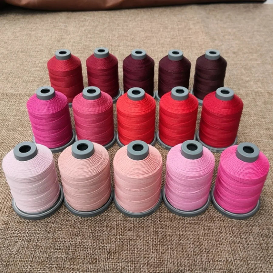 A collection of various colored wax thread embroidery cords arranged in a row.
