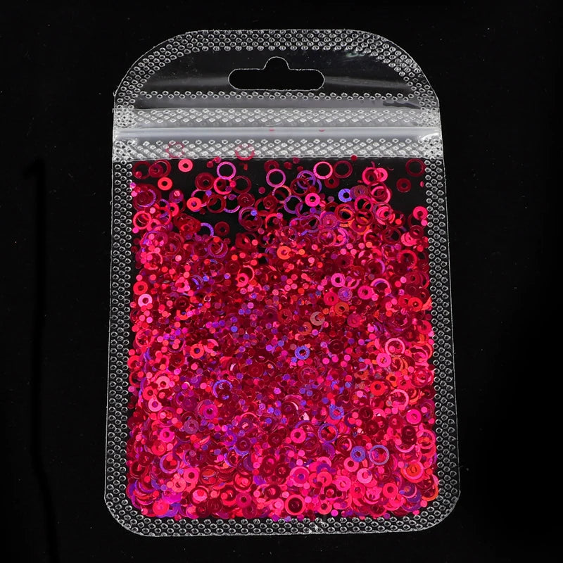 A clear plastic pouch filled with vibrant red and pink sparkly resin glitter filler for epoxy art.