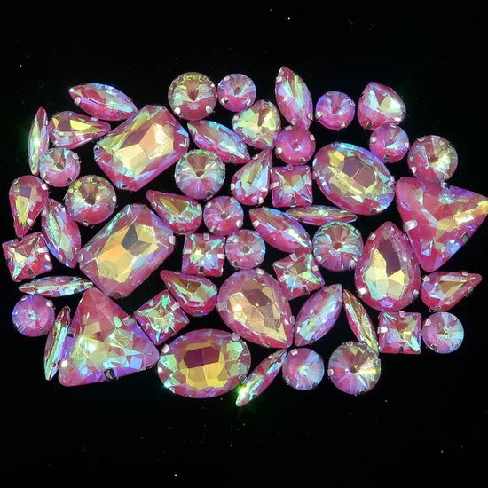 A collection of pink and purple faceted rhinestones arranged in a decorative pattern.