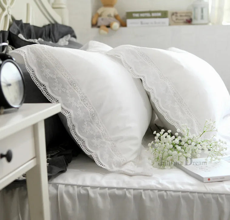 A white luxury ruffle duvet cover is displayed on a bed, featuring delicate lace trim.