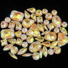 A collection of 50 faceted, golden-yellow and orange silver claw rhinestones arranged on a dark background.