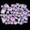 A collection of pink and purple faceted rhinestones and crystals arranged in a decorative pattern.