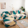 A stylish printed sofa protector cover in teal, gray, and yellow geometric pattern on a sofa.