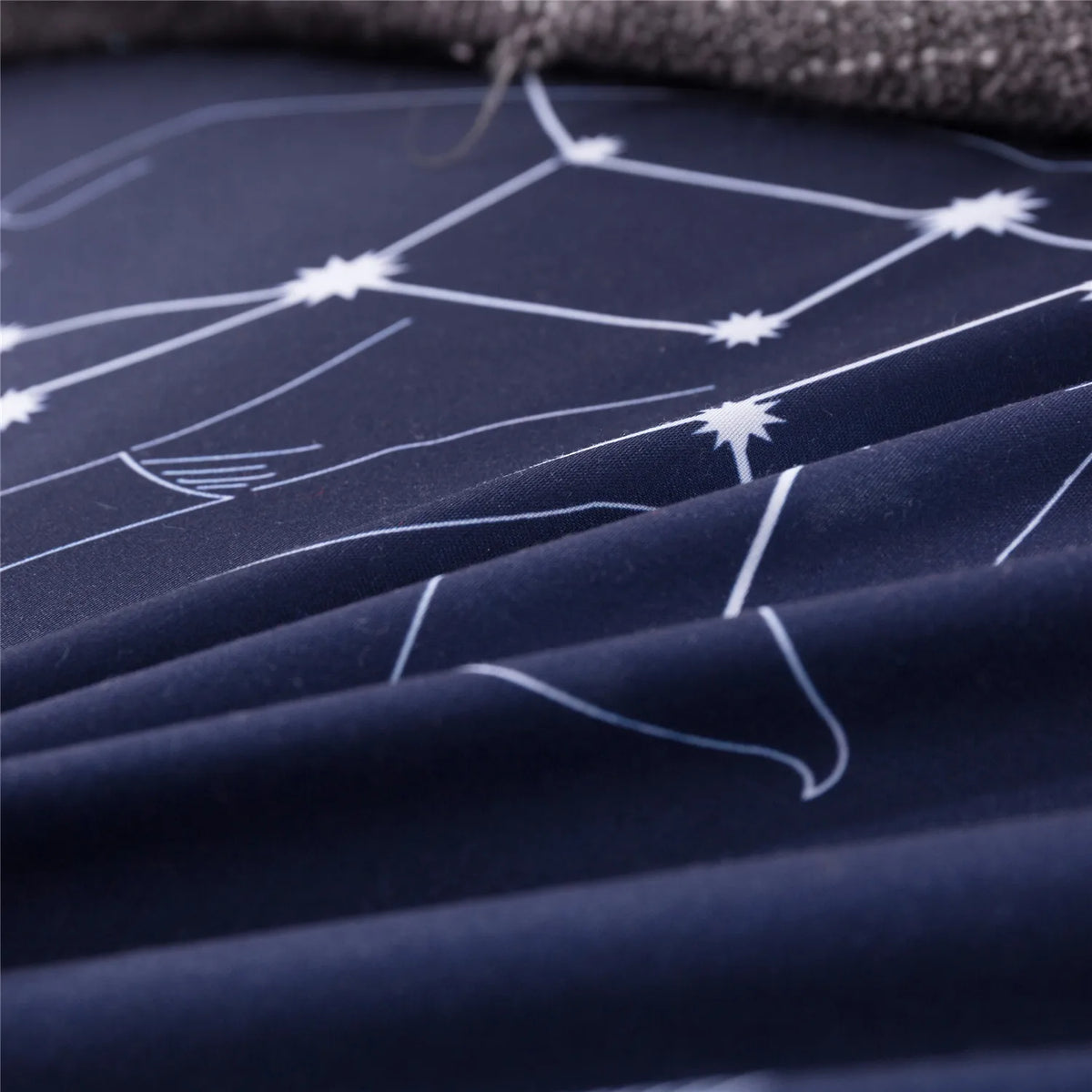 A dark blue duvet cover featuring a white constellation pattern on the fabric.