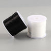 A spool of black flat elastic beading thread next to a roll of white flat elastic beading thread.