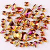A collection of silver claw rhinestones and gemstone decorations scattered on a white background.