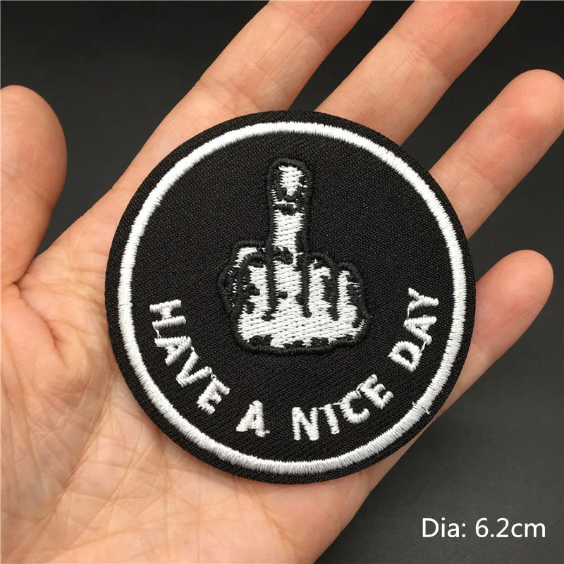 Black embroidered patch featuring a hand gesture and the text Have a Nice Day