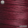 A spool of deep maroon waxed thread embroidery cord with a white logo visible in the top left corner.