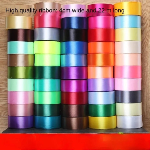 A vertical display of colorful satin ribbon rolls in various shades and lengths for gift wrapping and crafts.