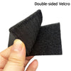 A hand holds a double-sided Velcro patch for tactical gear, showing the black fabric texture.