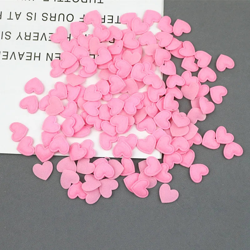 A pile of pink felt heart appliques for crafting and decoration.