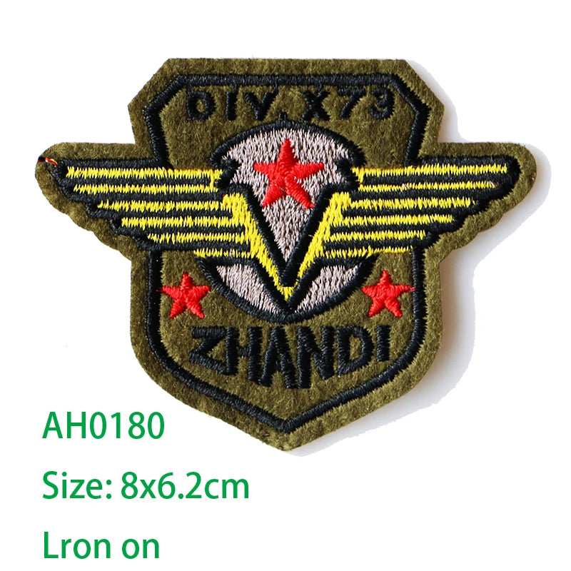 Embroidered iron-on patch featuring a dark olive green background with yellow wings and red stars, labeled OIV X79 and ZHANDI