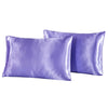 Two smooth purple silky satin pillowcases lying side by side.
