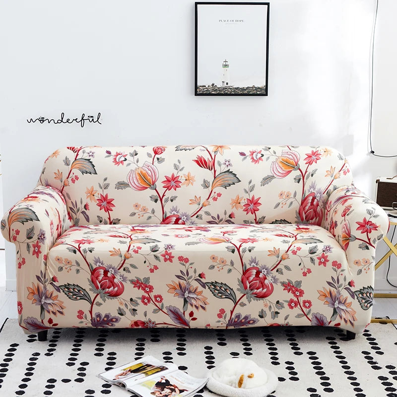 A floral patterned stretch elastic sofa cover in cream and pink tones displayed on a white rug.