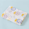 A folded muslin swaddle blanket featuring a light background with yellow and purple floral designs.