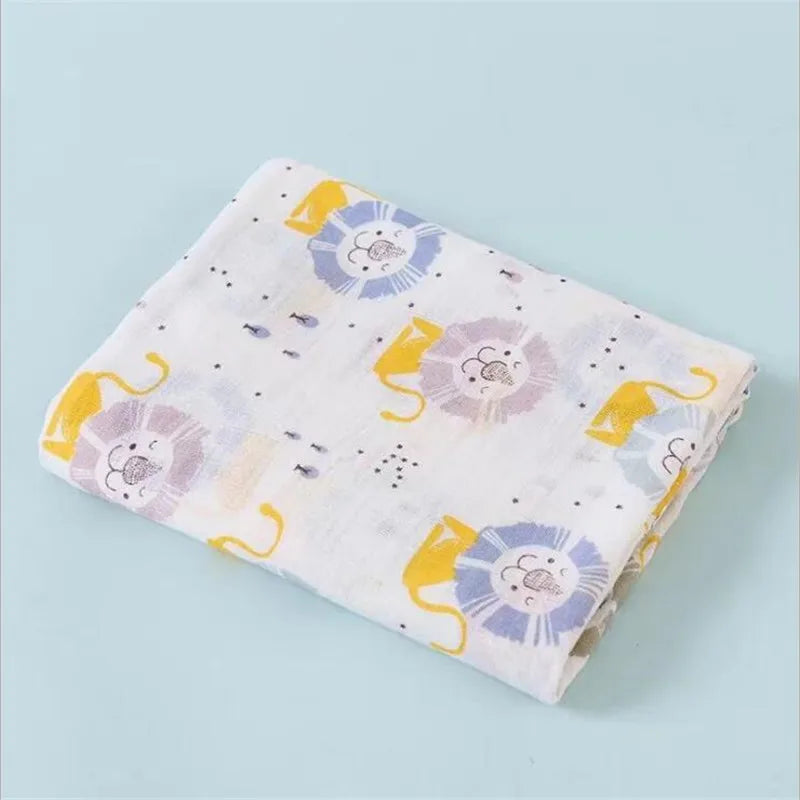 A folded muslin swaddle blanket featuring a light background with yellow and purple floral designs.