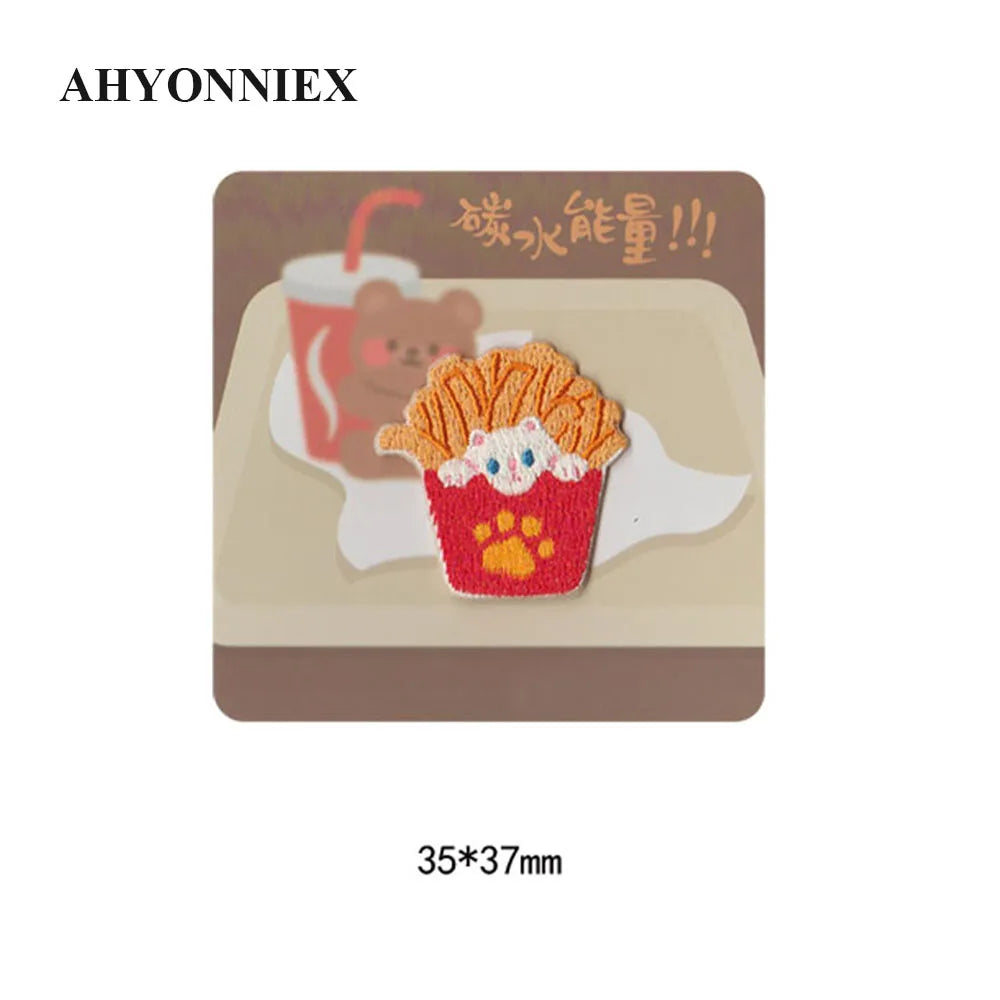 A square patch featuring an embroidered depiction of a fluffy orange food item, possibly a pastry or treat, with text in Chin