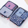 A set of six fabric storage organizers in various shades of pink and blue for clothes.