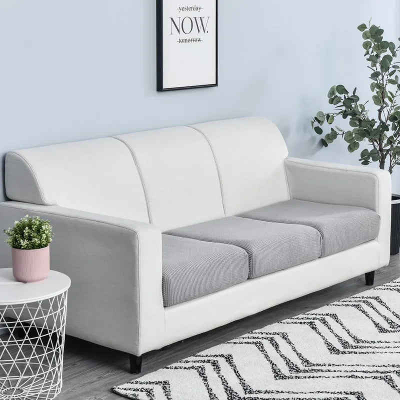A modern white sofa with a gray seat cushion cover displayed in a bright room.
