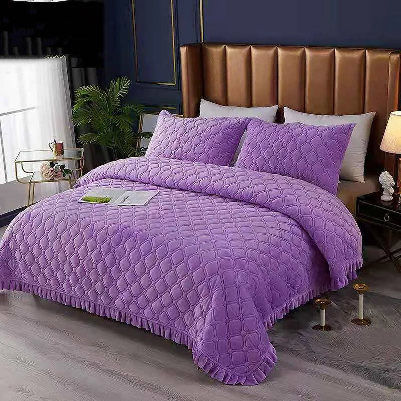 Purple crystal velvet quilted bedspread with white pillows on a bed.