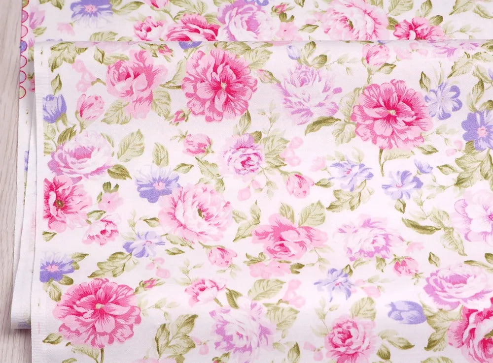 Pink floral and stripe cotton twill fabric featuring pink and purple roses on a white background