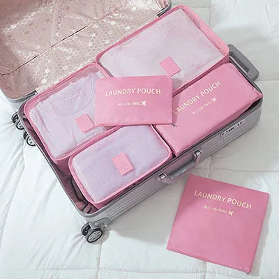 A pink and lavender 6-piece laundry pouch organizer set stored in a silver suitcase.