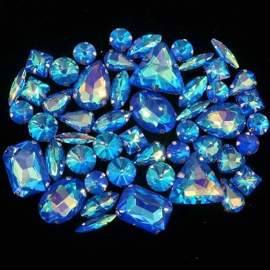 A cluster of brilliant blue and light blue faceted gemstones, including triangles and round cuts.