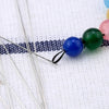 Precision stainless steel beading needles with colorful beads on a white background
