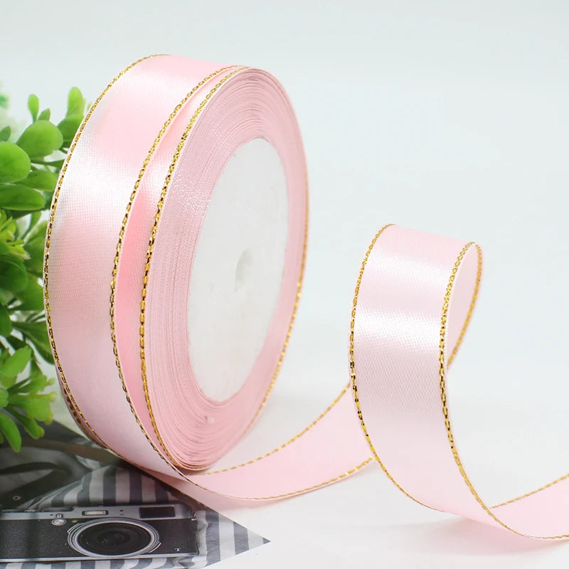 Roll of pink satin ribbon with gold edge for gift wrapping and crafts