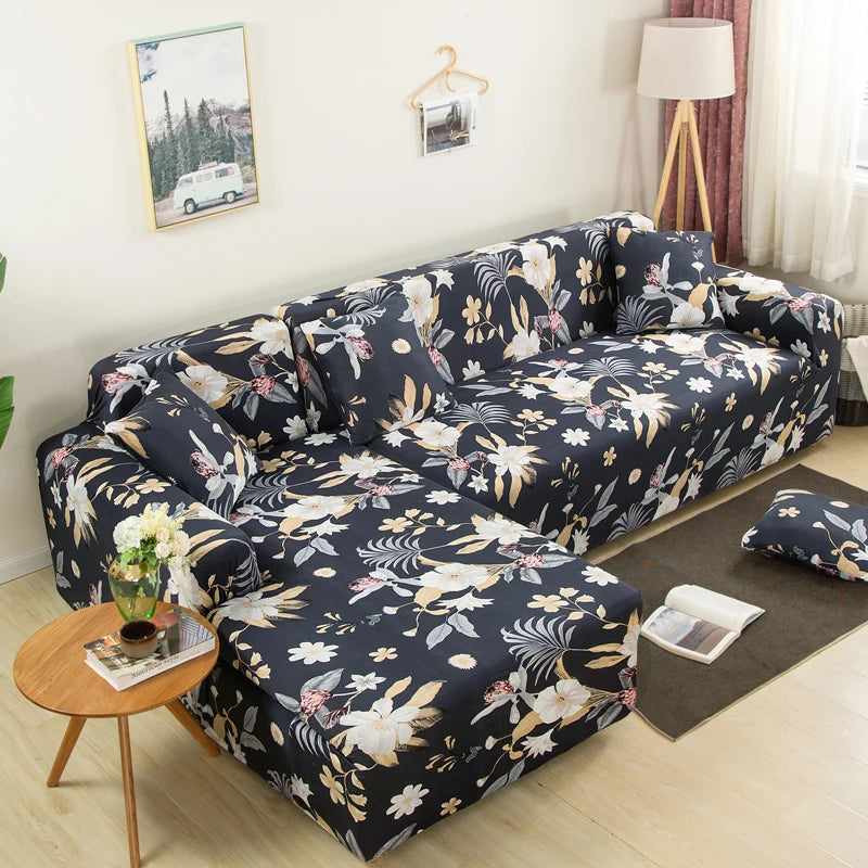 A dark floral patterned L-shaped sofa protector cover displayed on a light wood floor.