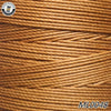 A close-up view of a spool of golden brown wax thread embroidery cord.
