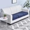 A white sofa with a dark blue seat cushion cover placed on a light rug.