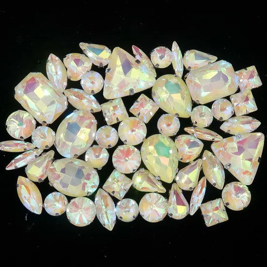 A collection of clear and iridescent silver claw rhinestones cut into various shapes and sizes.