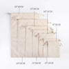 A set of ten natural beige cotton drawstring gift bags displayed in a vertical line with various sizes.