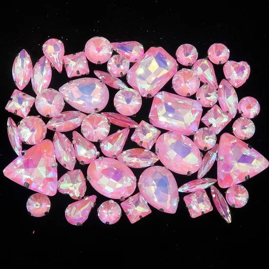 A collection of pink and iridescent faceted rhinestones arranged on a dark background.