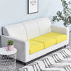 A modern white sofa with a yellow seat cushion cover and a potted plant in a bright living room.