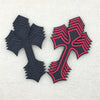 Two embroidered cross applique patches, one black and one pink, displayed against a light background.