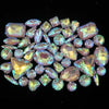 A collection of iridescent silver and pink gemstones, including various cut rhinestones, arranged in a cluster.