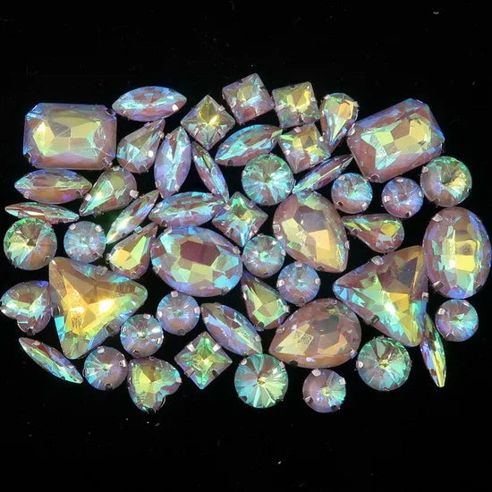 A collection of iridescent silver and pink gemstones, including various cut rhinestones, arranged in a cluster.