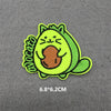 A bright lime green embroidered patch of a cute cat face with orange paws and ears.