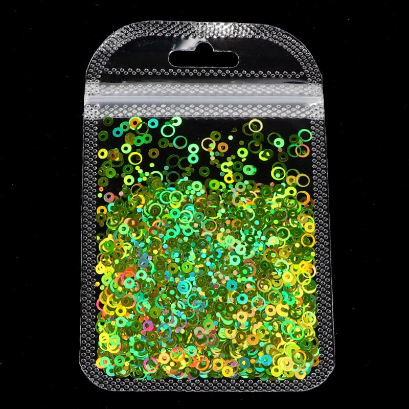 A clear plastic pouch filled with vibrant green and gold sparkly resin glitter for epoxy art
