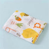 A soft cotton muslin swaddle blanket featuring yellow bee and orange fruit designs on a light background.