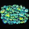 A collection of brilliant, faceted blue-green gemstones and rhinestones arranged in a cluster.